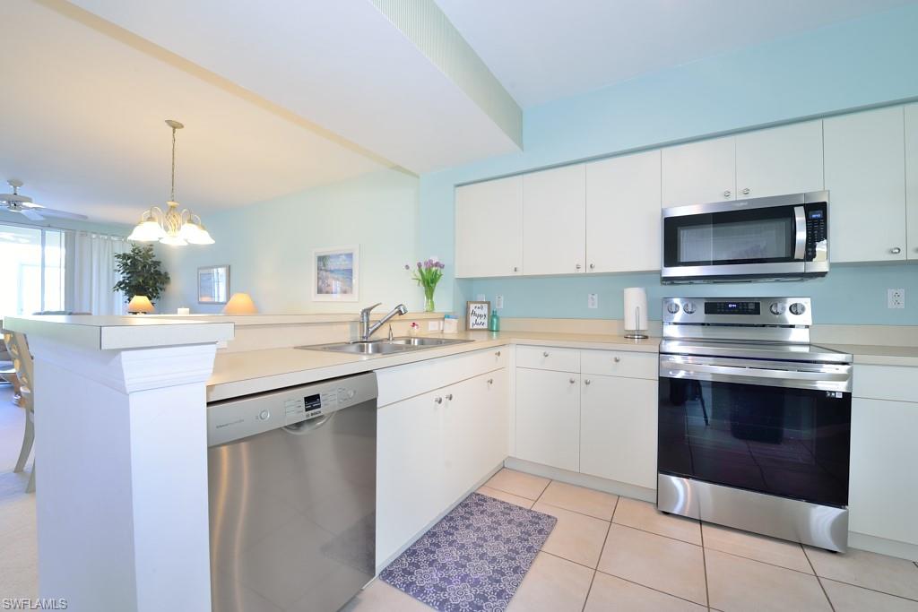 4960 Deerfield Way, Unit E102 Naples, FL 34110 - Photo 8 of 19 a kitchen with a sink stove and microwave