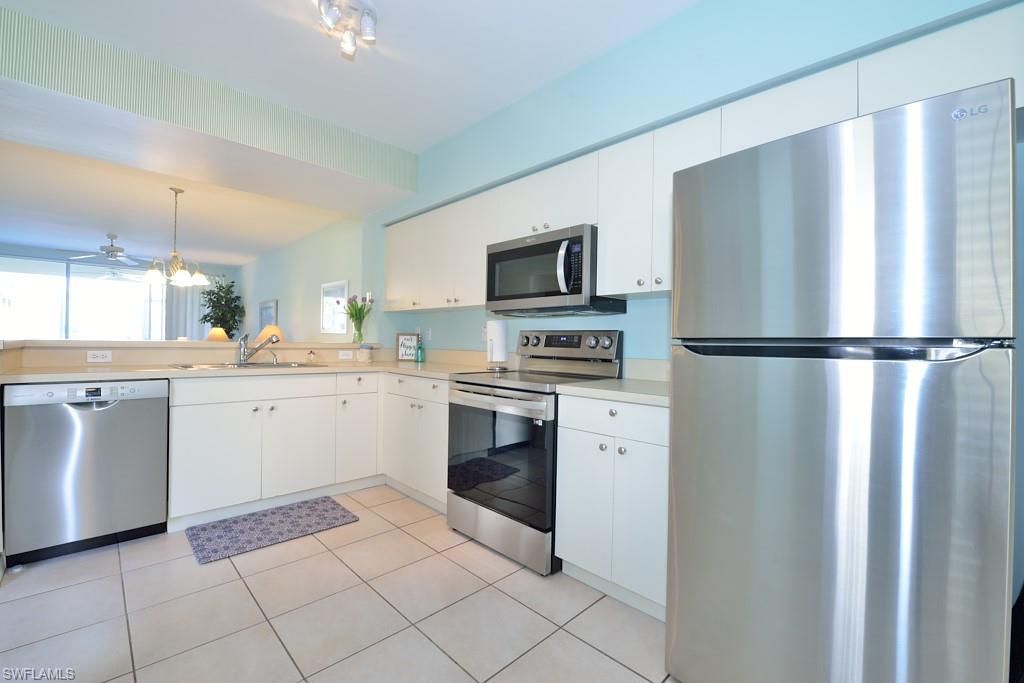 4960 Deerfield Way, Unit E102 Naples, FL 34110 - Photo 9 of 19 a kitchen with a refrigerator sink and microwave