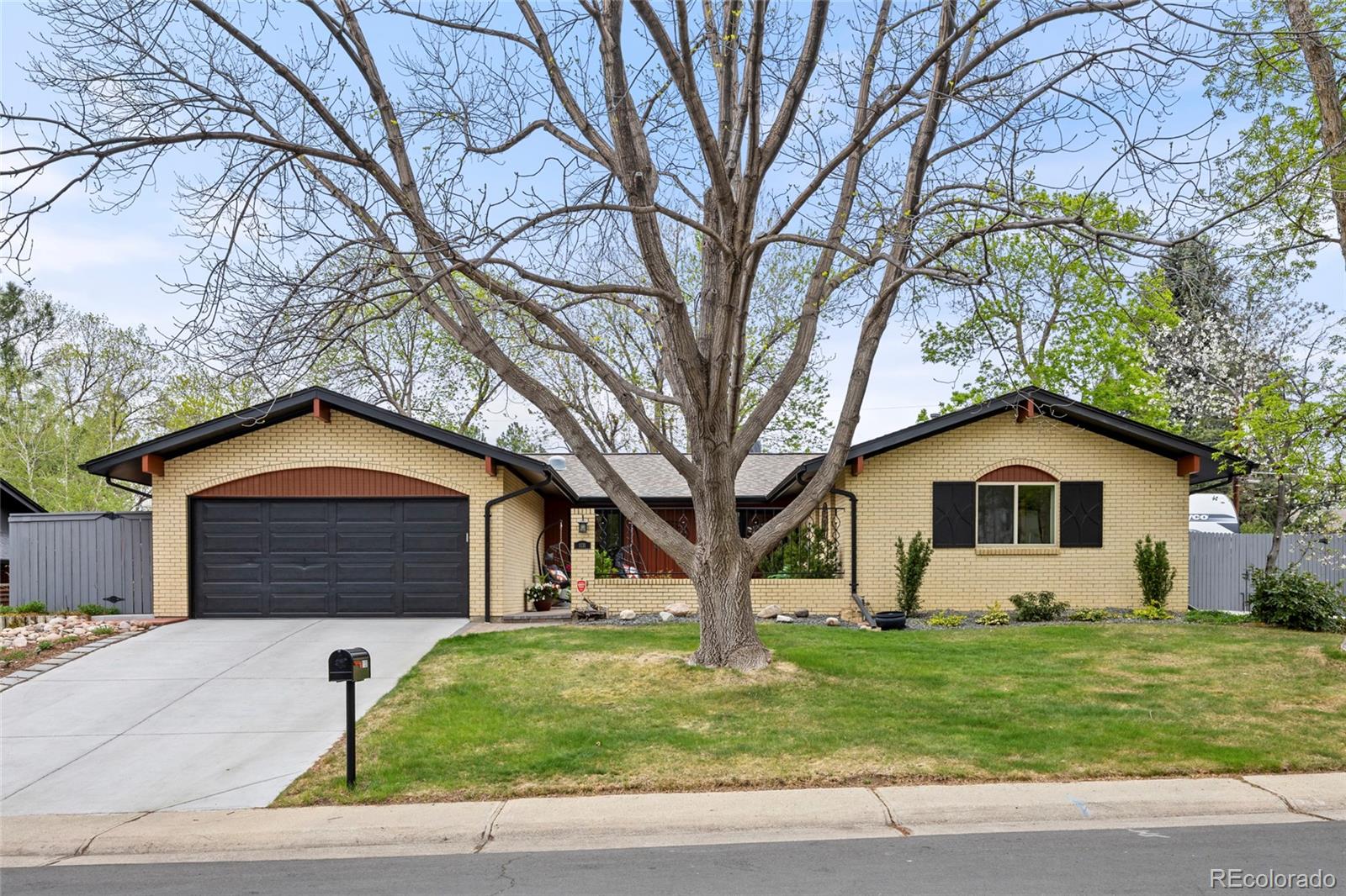 a front view of a house with a garden and trees