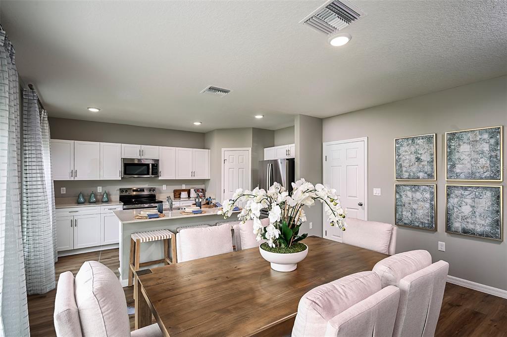 1346 Palmeroy Road Haines City, FL 33844 - Photo 11 of 23 a kitchen with a dining table chairs stainless steel appliances and cabinets