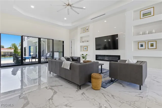 a living room with furniture a large window and a view of kitchen
