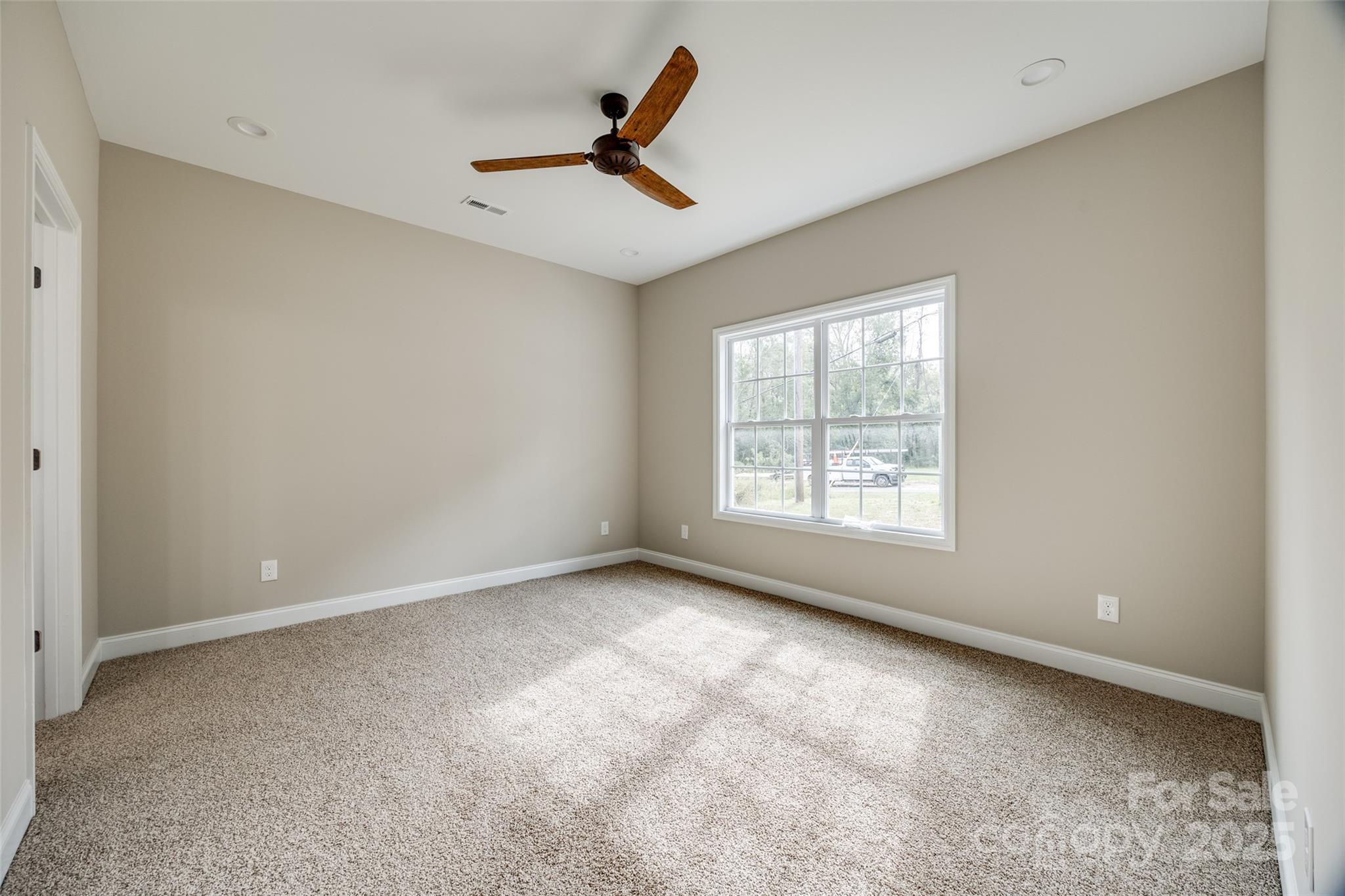 1960 Powell Avenue Lancaster, SC 29720 - Photo 6 of 13 an empty room with windows and ceiling fan
