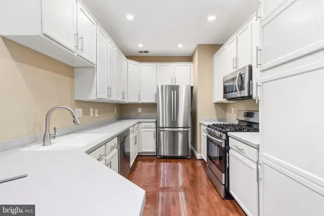 a kitchen with granite countertop a refrigerator stove and microwave
