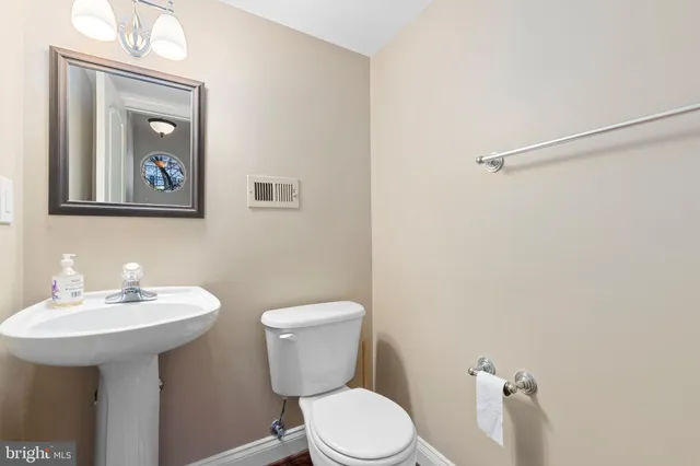 a bathroom with a toilet a sink and mirror