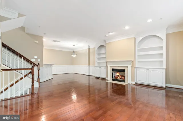 a view of empty room with wooden floor and fireplace
