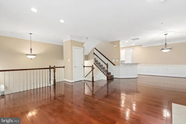 a view of an empty room with wooden floor fireplace and a window