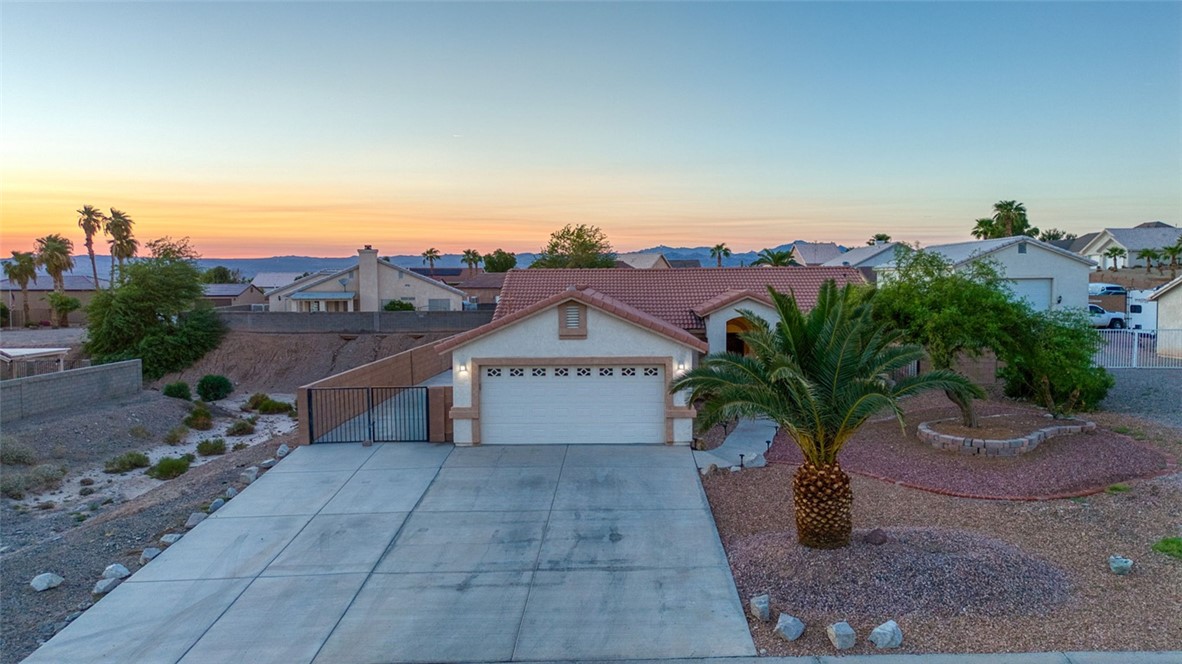 2213 Jamie Road Fort Mohave, AZ 86426 - Photo 1 of 51 View of front facade featuring driveway, stucco siding, a residential view, and a garage