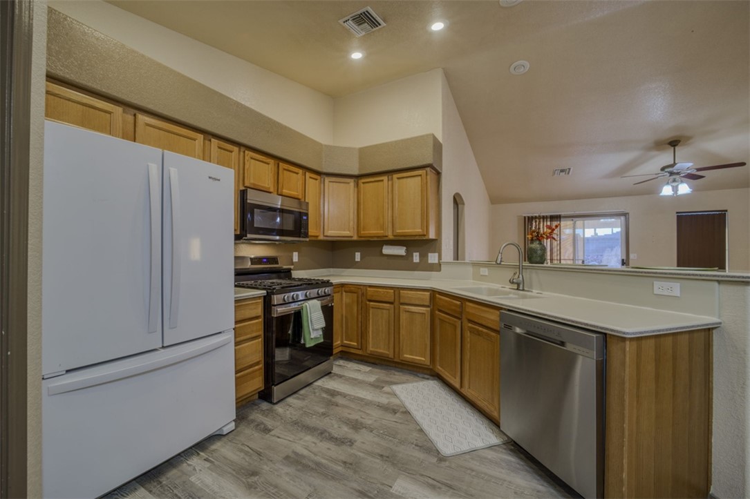 2213 Jamie Road Fort Mohave, AZ 86426 - Photo 11 of 51 Kitchen featuring stainless steel appliances, vaulted ceiling, light countertops, a peninsula, and light wood-style flooring