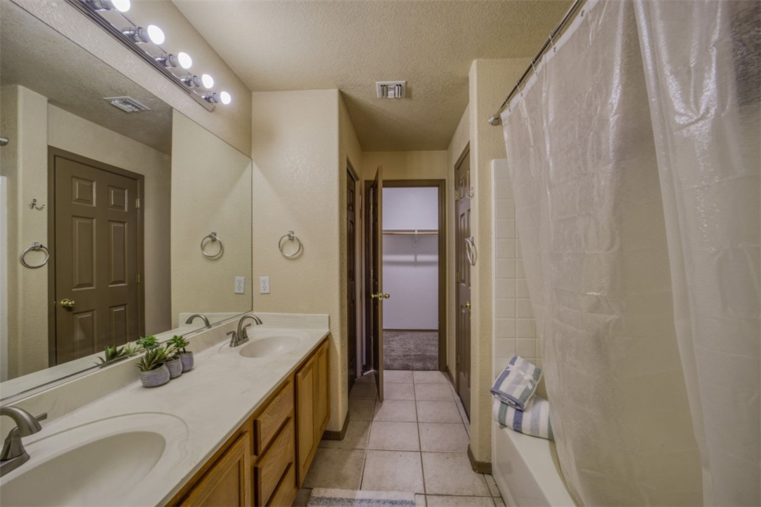 2213 Jamie Road Fort Mohave, AZ 86426 - Photo 17 of 51 Full bath featuring a textured ceiling, light tile patterned floors, a spacious closet, double vanity, and shower / tub combo