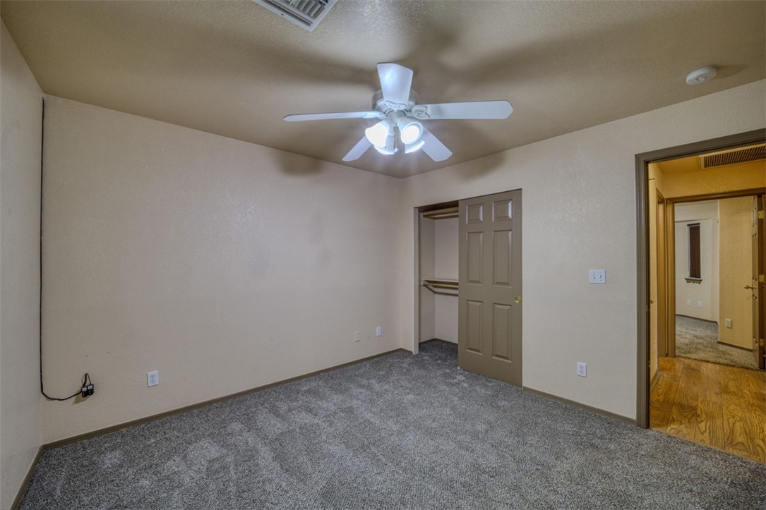 2213 Jamie Road Fort Mohave, AZ 86426 - Photo 19 of 51 Unfurnished bedroom featuring carpet, a closet, and a ceiling fan