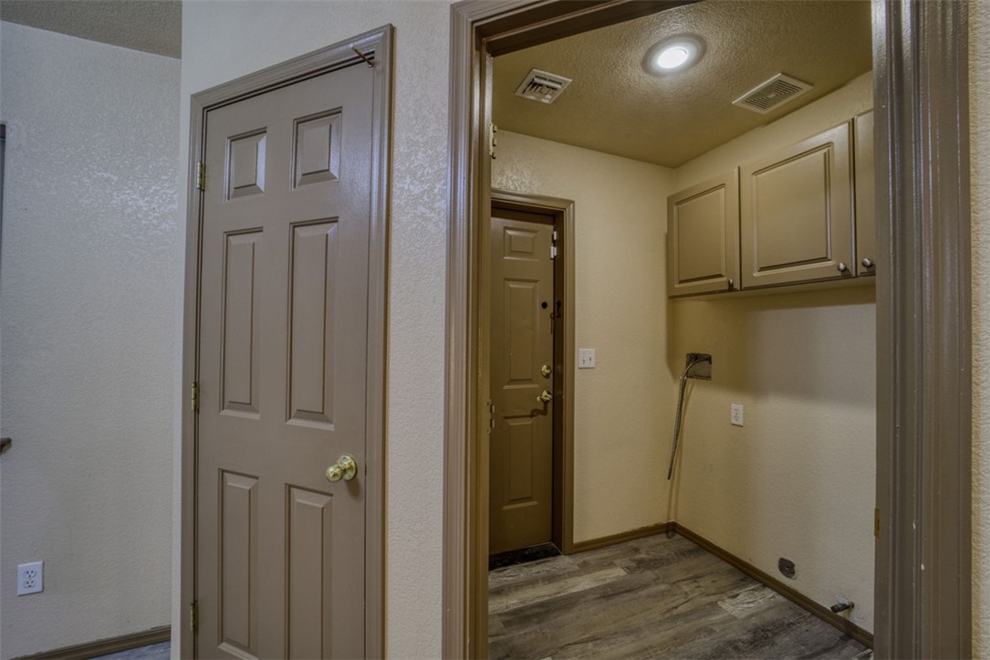 2213 Jamie Road Fort Mohave, AZ 86426 - Photo 27 of 51 Laundry room featuring dark wood-type flooring, a textured ceiling, and a textured wall