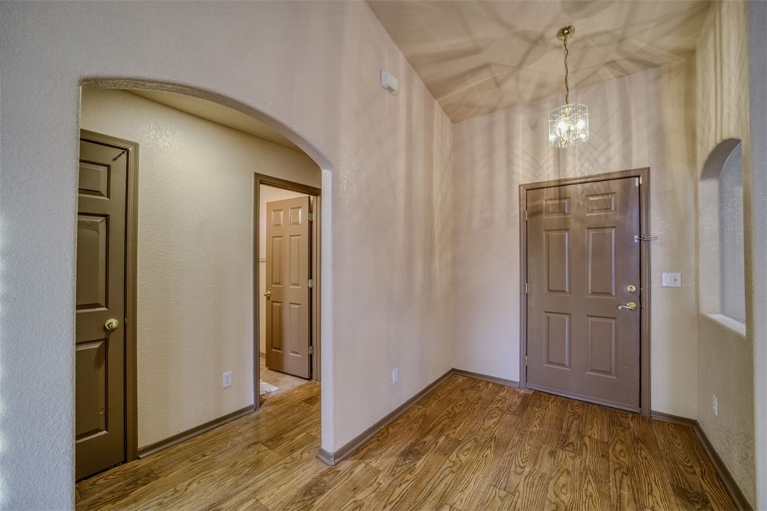 2213 Jamie Road Fort Mohave, AZ 86426 - Photo 3 of 51 Foyer entrance with wood finished floors, arched walkways, and a chandelier