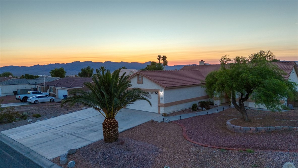 2213 Jamie Road Fort Mohave, AZ 86426 - Photo 45 of 51 View of front of home with a tile roof, concrete driveway, a garage, stucco siding, and a chimney