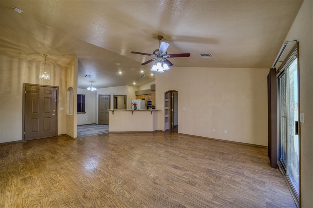 2213 Jamie Road Fort Mohave, AZ 86426 - Photo 5 of 51 Unfurnished living room with lofted ceiling, arched walkways, dark wood-style flooring, and a ceiling fan