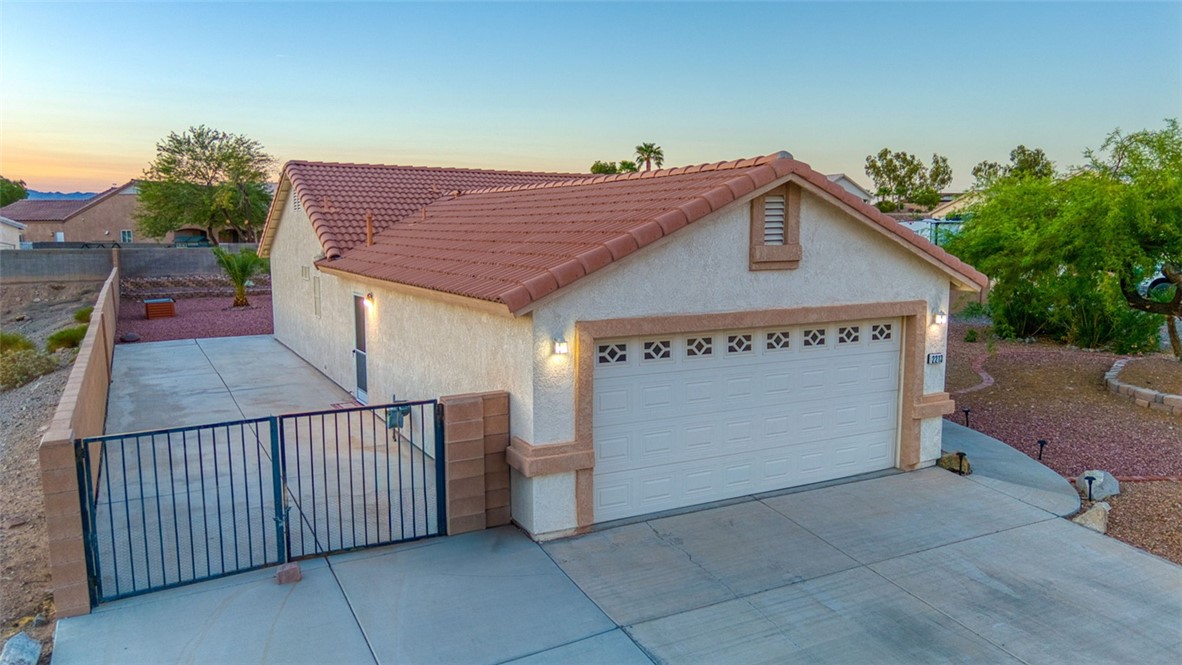 2213 Jamie Road Fort Mohave, AZ 86426 - Photo 51 of 51 View of front of property featuring stucco siding, driveway, a gate, a tile roof, and a garage