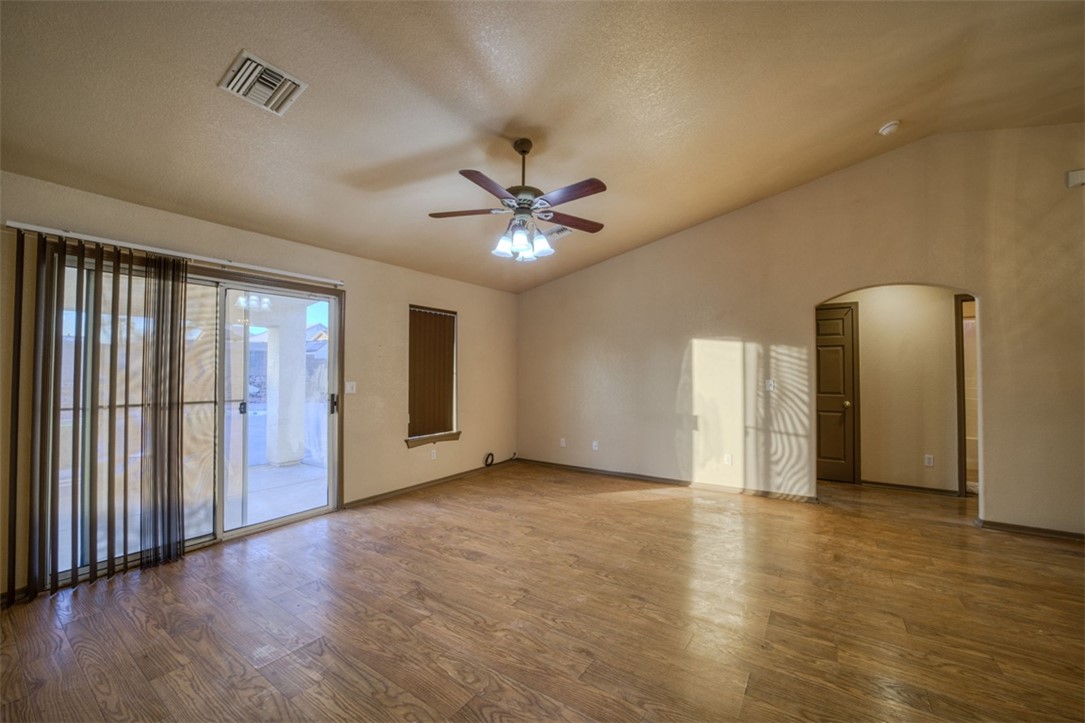 2213 Jamie Road Fort Mohave, AZ 86426 - Photo 7 of 51 Spare room featuring lofted ceiling, wood finished floors, arched walkways, a ceiling fan, and a textured ceiling