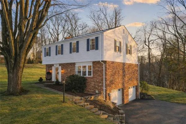 a view of a house with yard and tree s