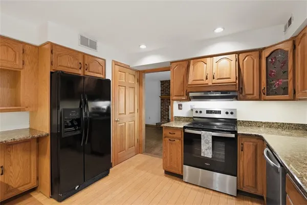 a kitchen with stainless steel appliances granite countertop a refrigerator stove and oven