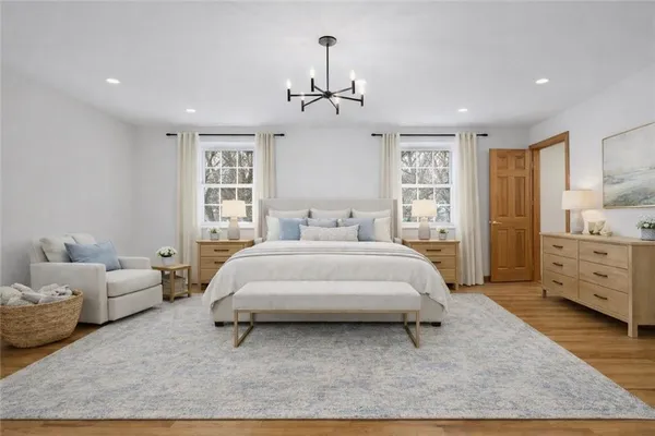 a spacious bedroom with a bed and a chandelier