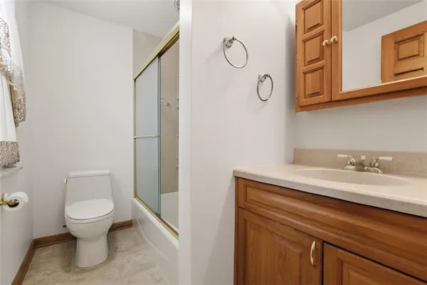 a bathroom with a granite countertop toilet sink and mirror