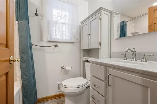 a bathroom with a granite countertop toilet sink and mirror