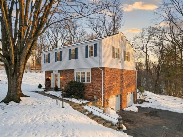 a view of a house with a yard covered in snow