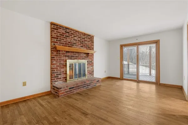 an empty room with wooden floor and fireplace