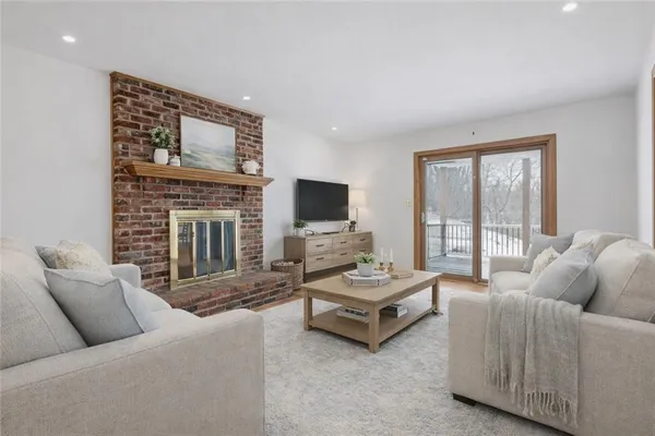 a living room with furniture a flat screen tv and a fireplace