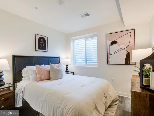 a bedroom with a bed and a painting on the wall