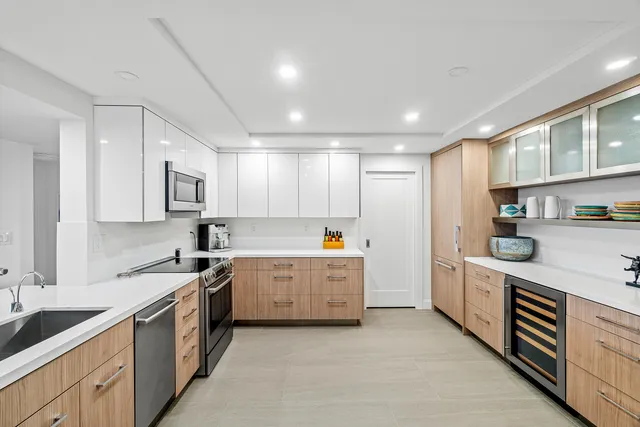 a large kitchen with stainless steel appliances granite countertop a lot of counter space and wooden floors