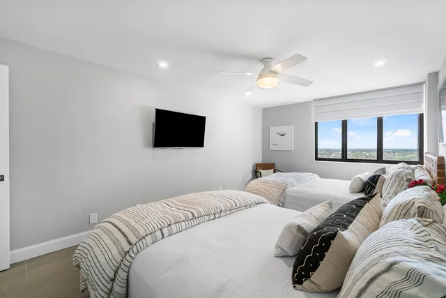 a bedroom with two beds and a flat screen tv