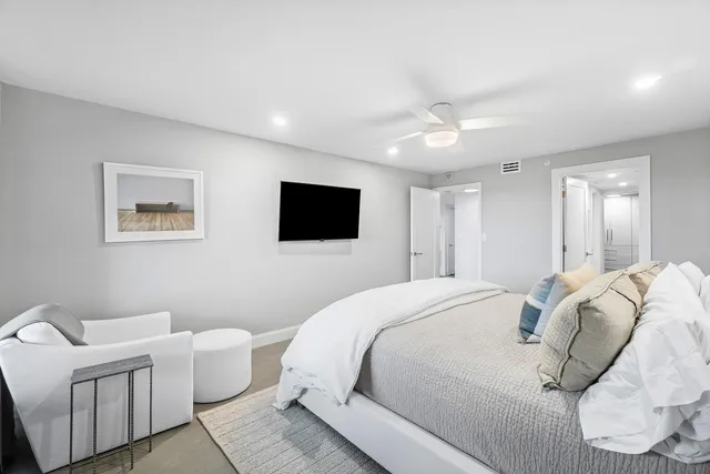 a spacious bedroom with a bed and a television