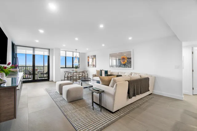 a living room with furniture and view of kitchen