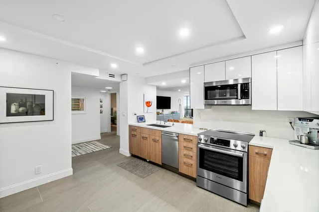 a kitchen with stainless steel appliances a stove microwave and sink