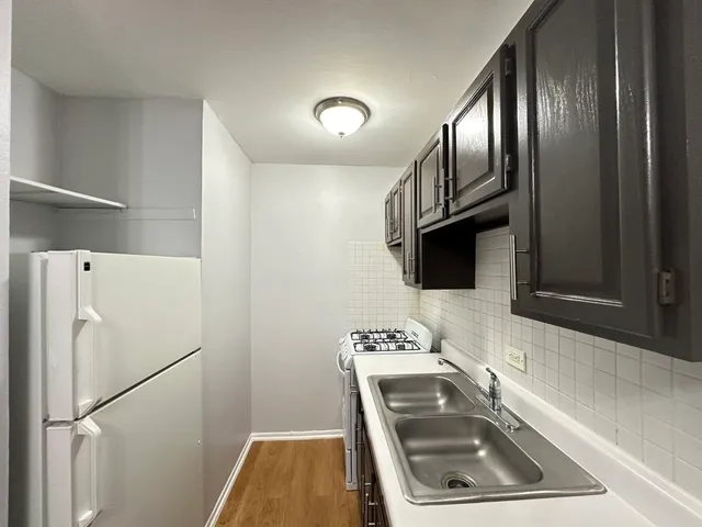 a kitchen with stainless steel appliances granite countertop a refrigerator a stove a sink and a microwave