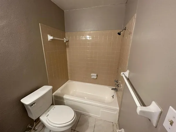 a white toilet sitting next to a bath tub
