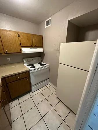 a kitchen with a refrigerator and a stove top oven