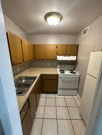 a kitchen with a sink a stove and a refrigerator