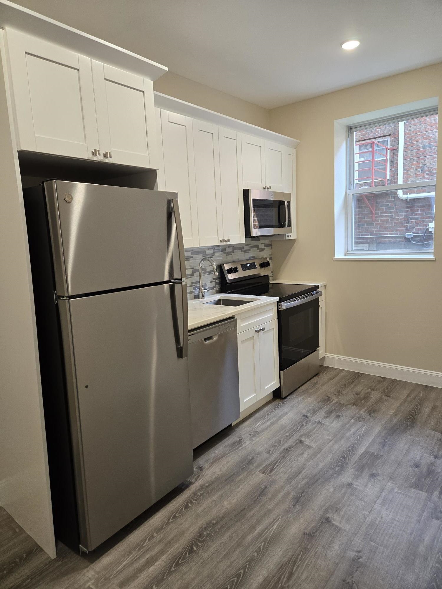 289 Day Avenue, Unit A2 Fairview, NJ 07022 - Photo 1 of 6 a kitchen with stainless steel appliances a refrigerator sink and microwave