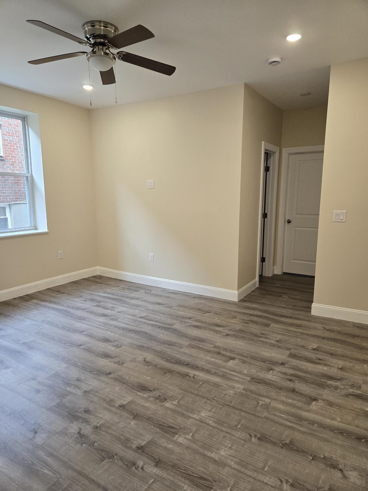 289 Day Avenue, Unit A2 Fairview, NJ 07022 - Photo 3 of 6 wooden floor in an empty room with a window
