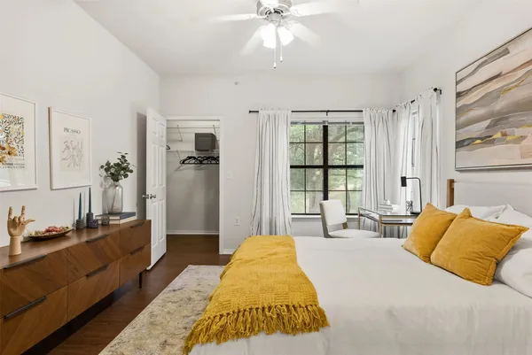 a spacious bedroom with a bed and a chandelier