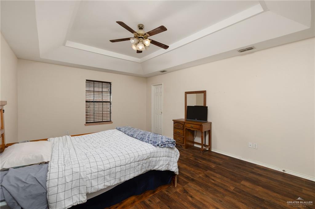 2210 Morning Lane Mission, TX 78572 - Photo 8 of 20 a bedroom with a large bed a chandelier and a window