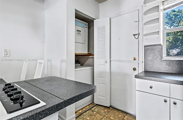 a kitchen with granite countertop a stove a sink a refrigerator and window