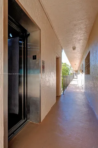 a front view of multi story residential apartment building with yard and outdoor seating