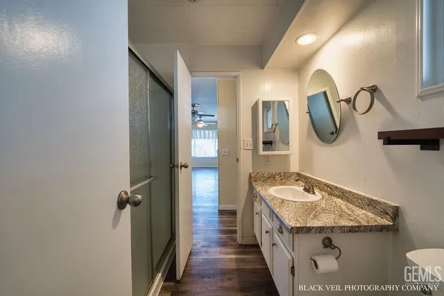 a bathroom with a granite countertop sink and a mirror