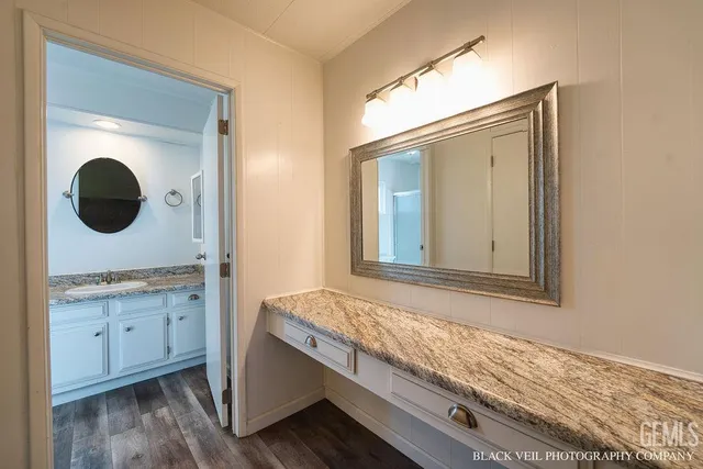 a bathroom with a granite countertop sink and a mirror