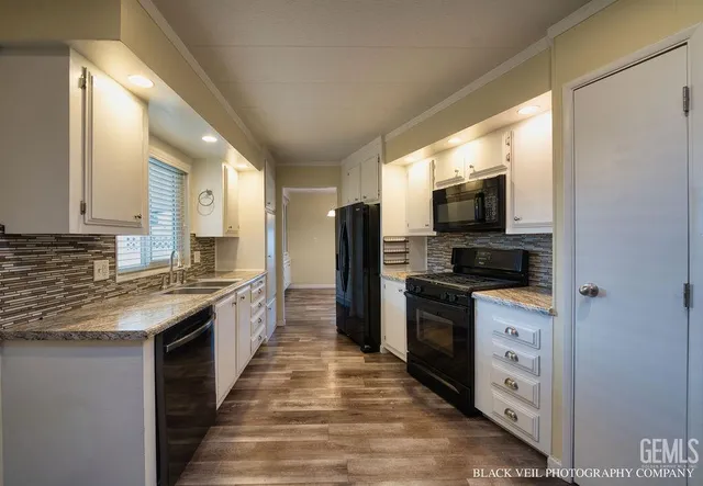 a large kitchen with stainless steel appliances granite countertop a stove and a sink