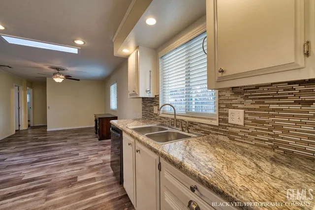 a kitchen with granite countertop a sink and a stove