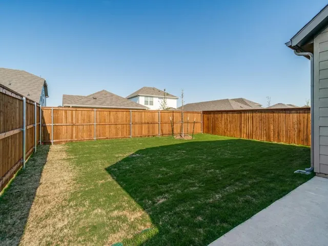 a view of a backyard with wooden fence