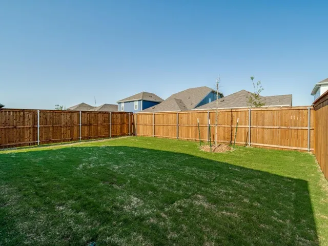 a view of a green field with wooden fence